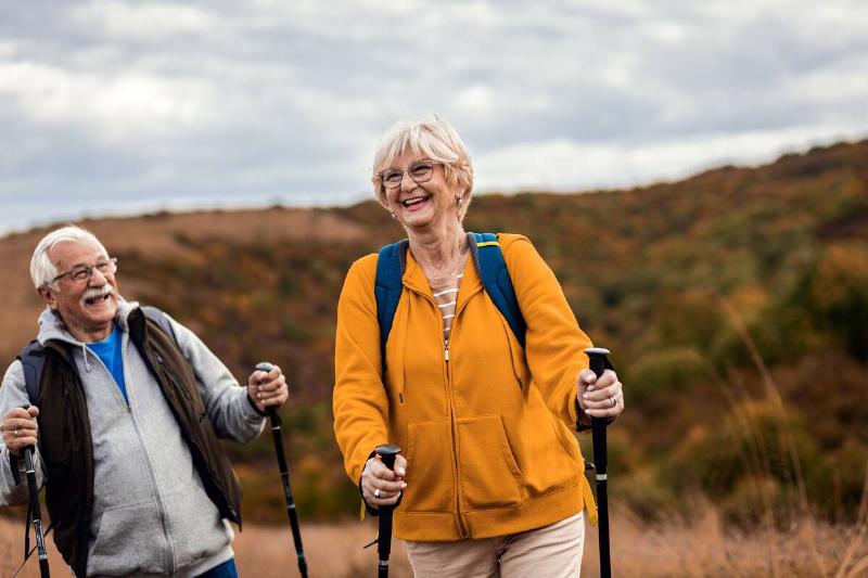 A couple hiking with hiking poles. 