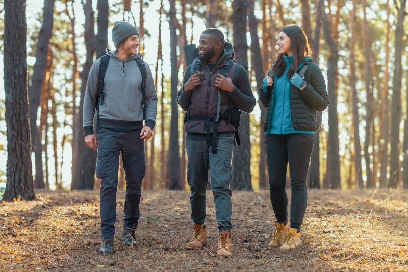 Three people dressed in layers on a hike. 