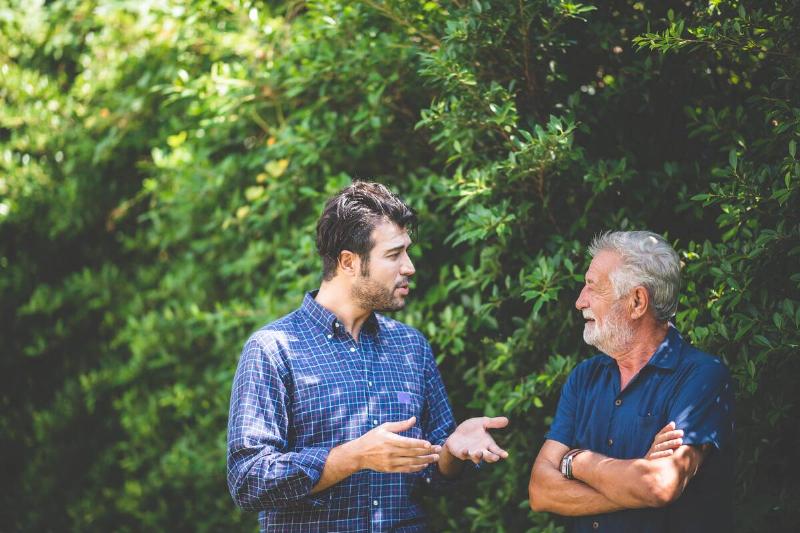 Wildlife expert explaining something to man. 