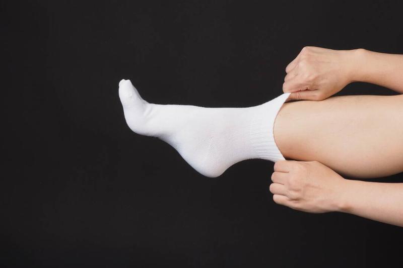 Hands pulling on white socks.