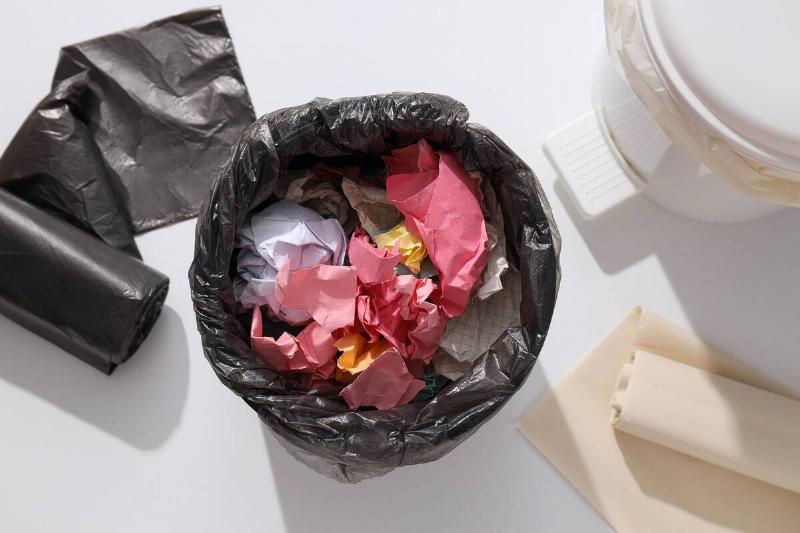 Bag of garbage with paper on top.