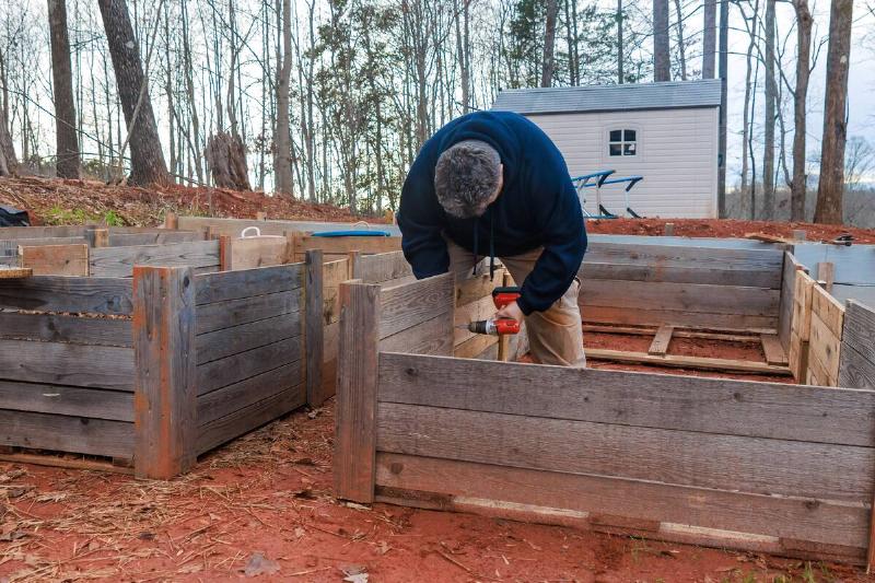 Man building raised garden beds.