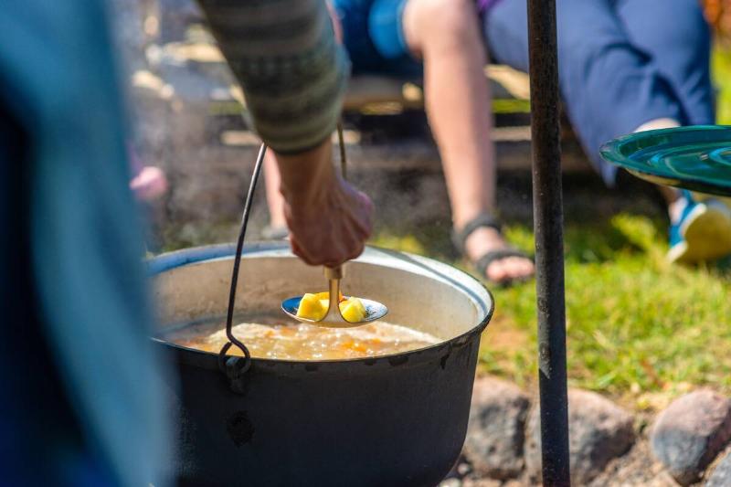 Cooking food in a pot on campfire.