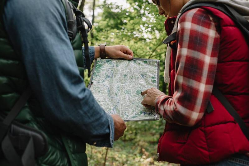 Man and woman reading hiking map together. 