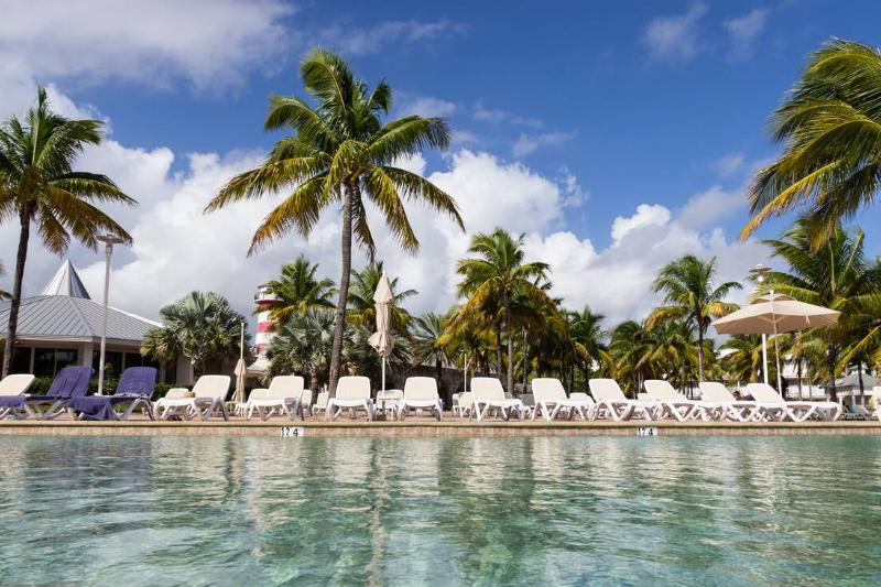 Pool chairs around a pool at a resort.
