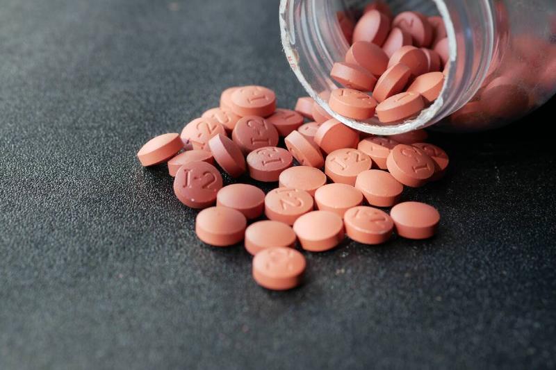 Ibuprofen pills spilling from jar.  