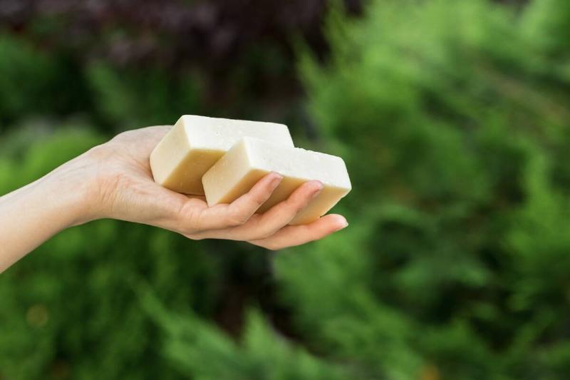 Hand holding two bars of soap.