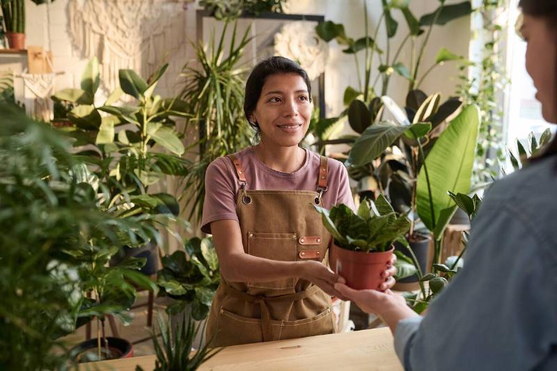 Woman selling plant at garden center. 
