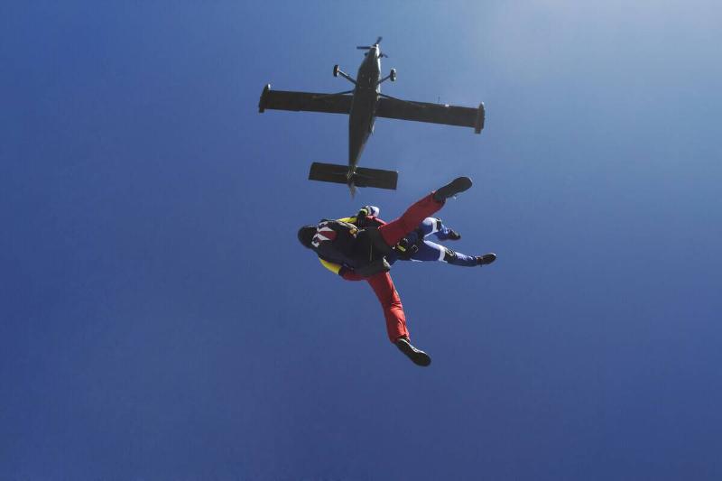 Freeflying skydivers in blue sky.