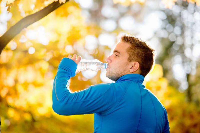 Man drinking water in fall.