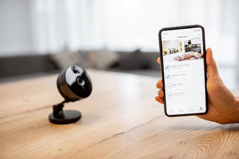 Phone and camera connected on smart home security technology. 