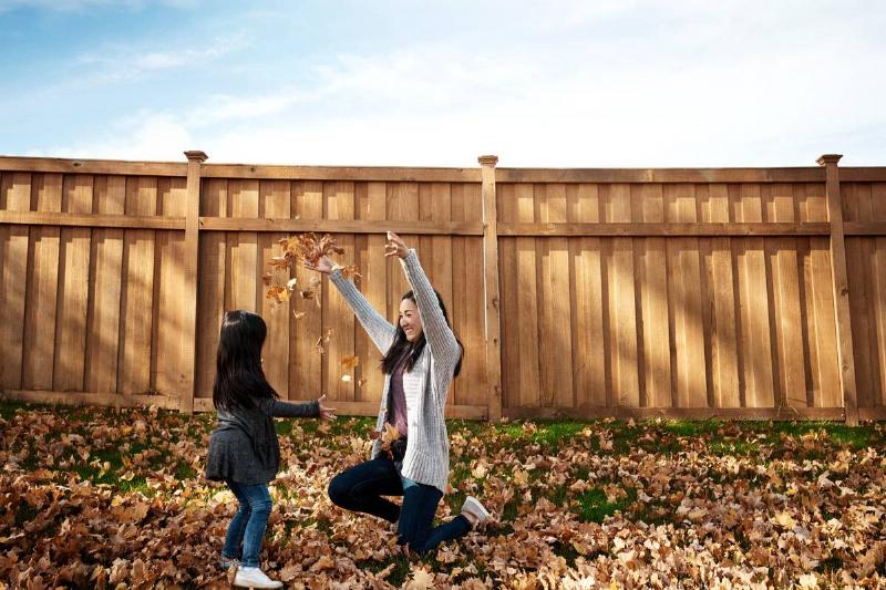 Woman and child playing in leaves. 