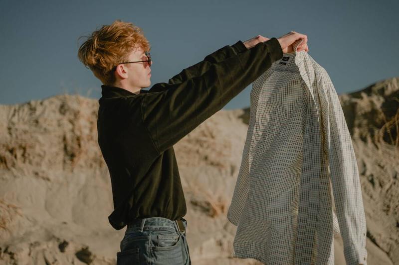 Man holding shirt in hands.