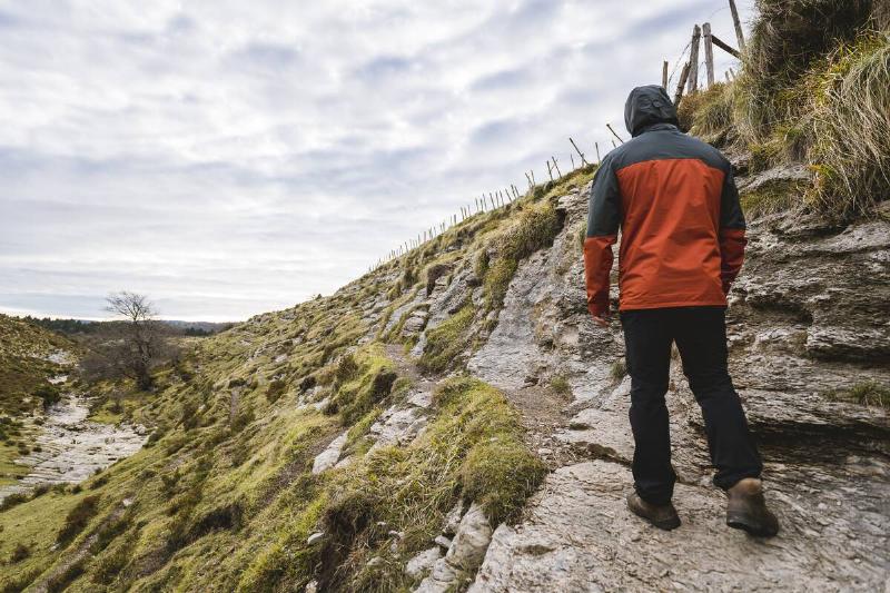 Man walking on hill near valley. 