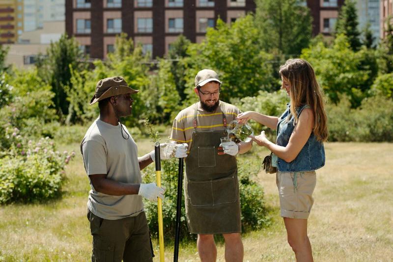 Three young people working together on community gardening project.