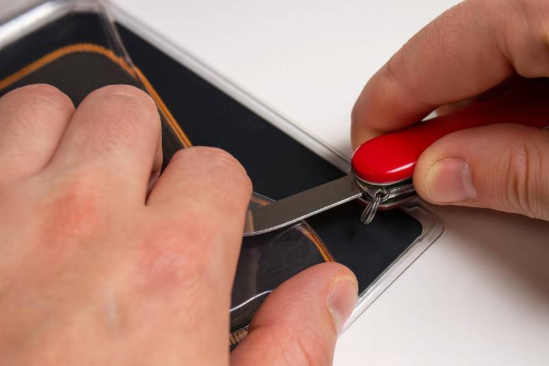 Using a Swiss Army Knife to open plastic packaging.