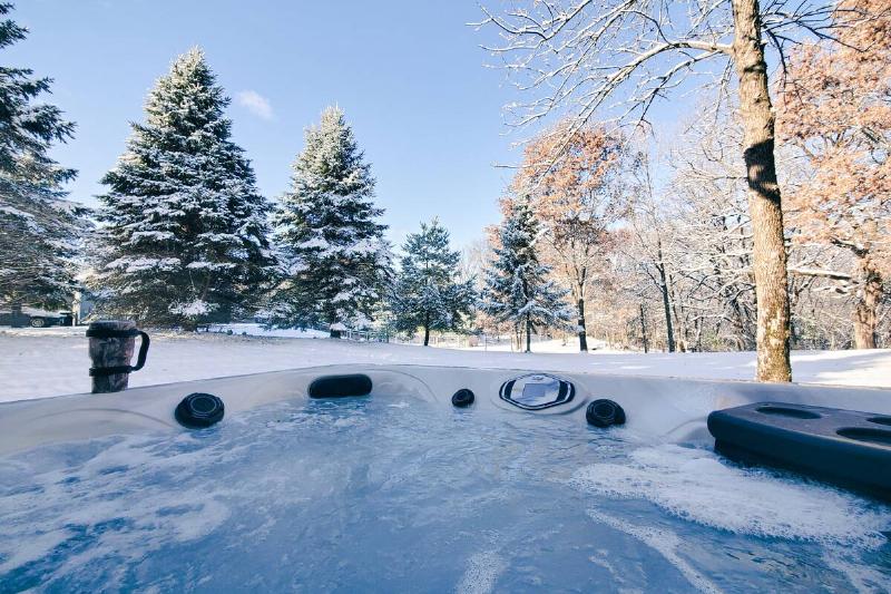 Hot tub in front of a snowy landscape. 
