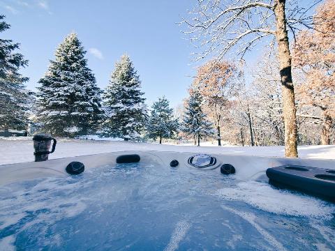Hot tub in front of a snowy landscape. 