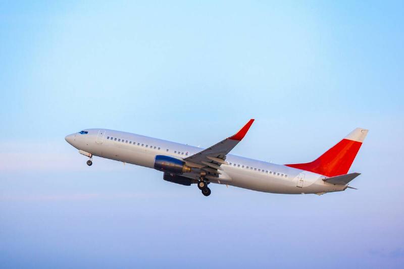 Passenger plane taking off from runway at airport on sunny day