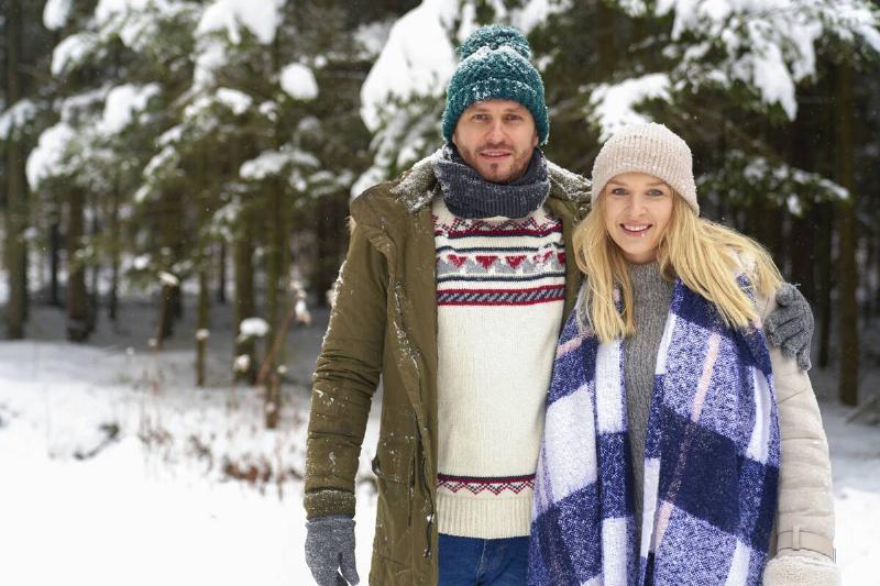 Couple dressed for winter in snow.