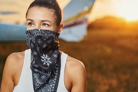 Woman's face covered by bandana.