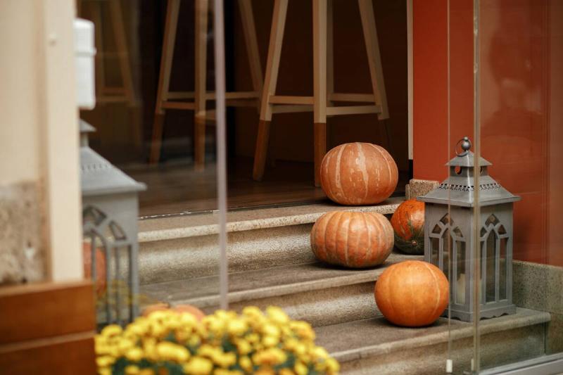 Pumpkins and lanterns on a stoop. 
