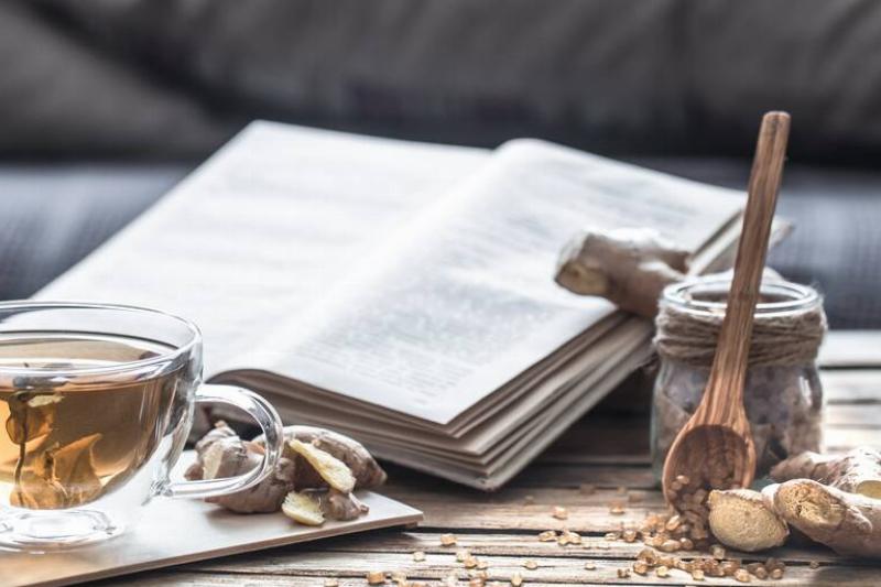 Cookbook on a table with a cup of tea. 