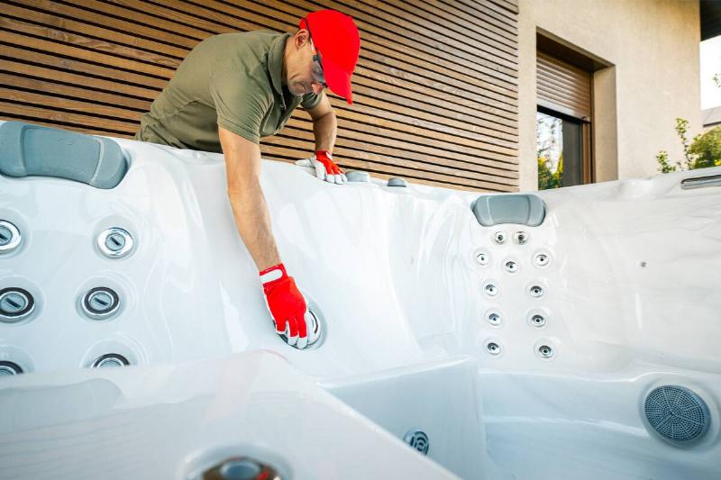 Man cleaning empty hot tub. 