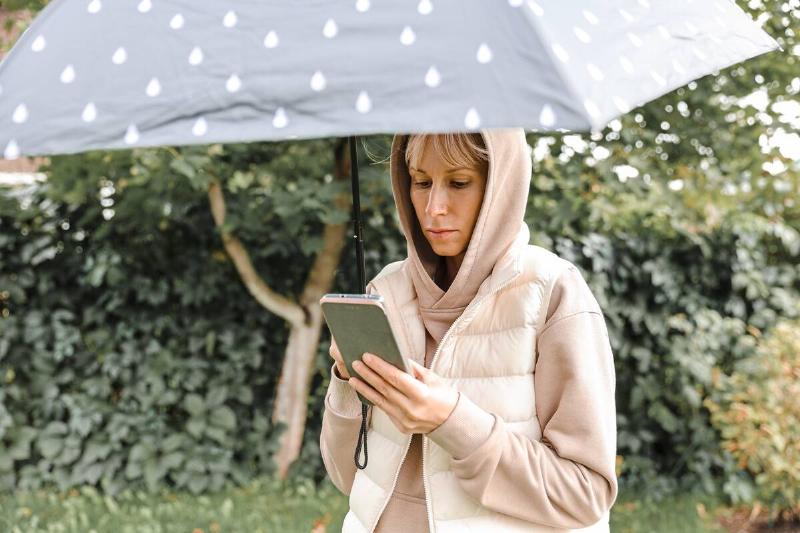 Woman checking forecast in the rain.