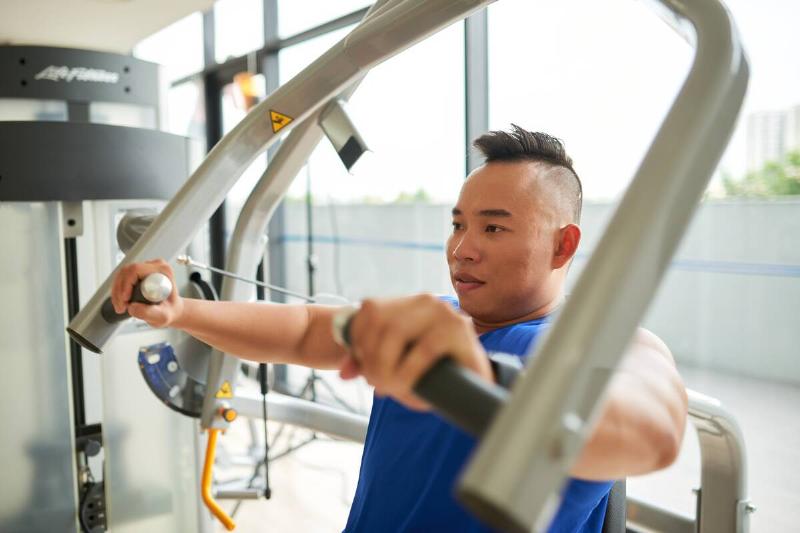 Vietnamese young man having training in gym.