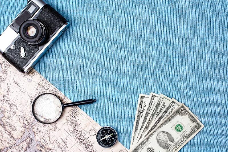 Travel accessories on blue knitted background.