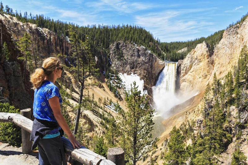 Tourist looking at waterfall in Yellowstone. 
