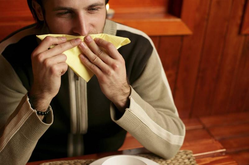Man wiping mouth with bandana.