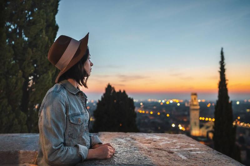 Young woman looking at night view of Verona.