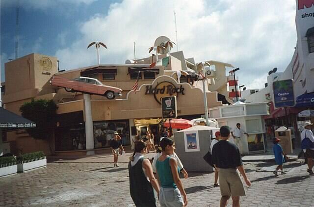 Tourists walking past a Hard Rock Cafe