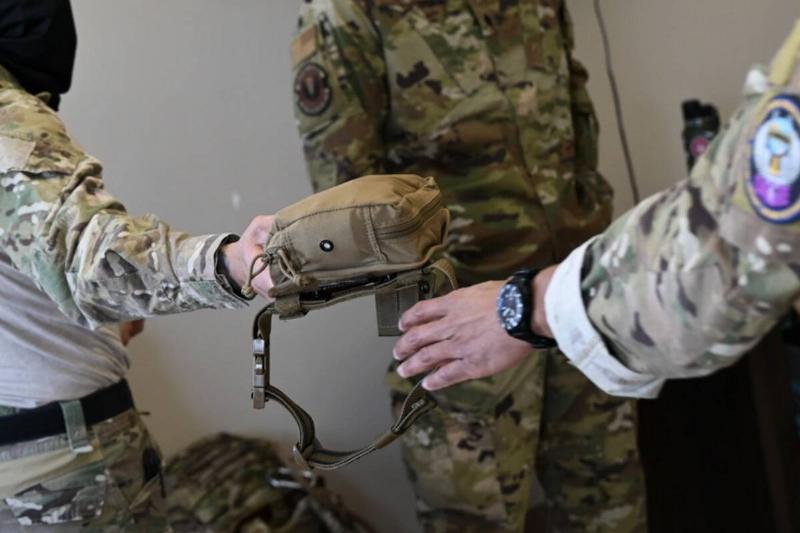 Soldier passing an IFAK to another soldier.