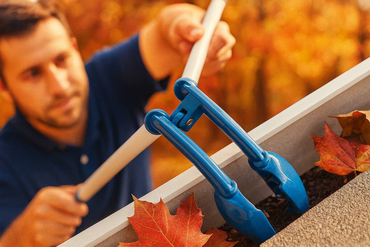 Man cleaning gutters using tongs.