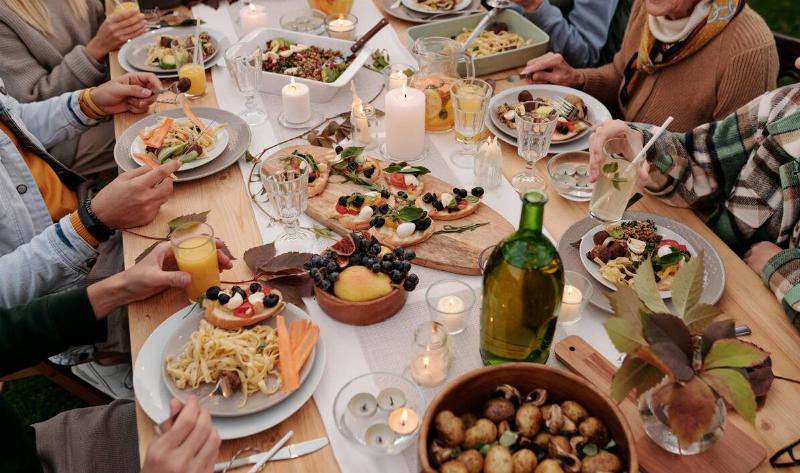 People sitting around a table full of food.