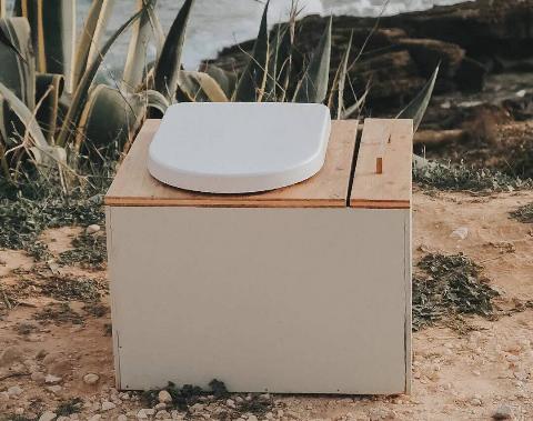 A wooden box with a toilet lid on top, a composting toilet.
