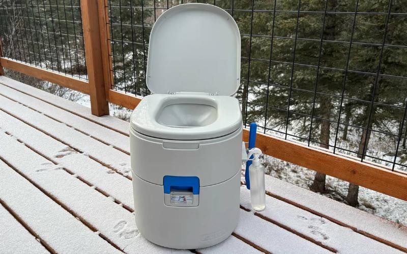 A portable flushing toilet on a deck.