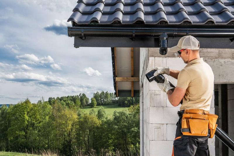 Construction worker installing gutters.