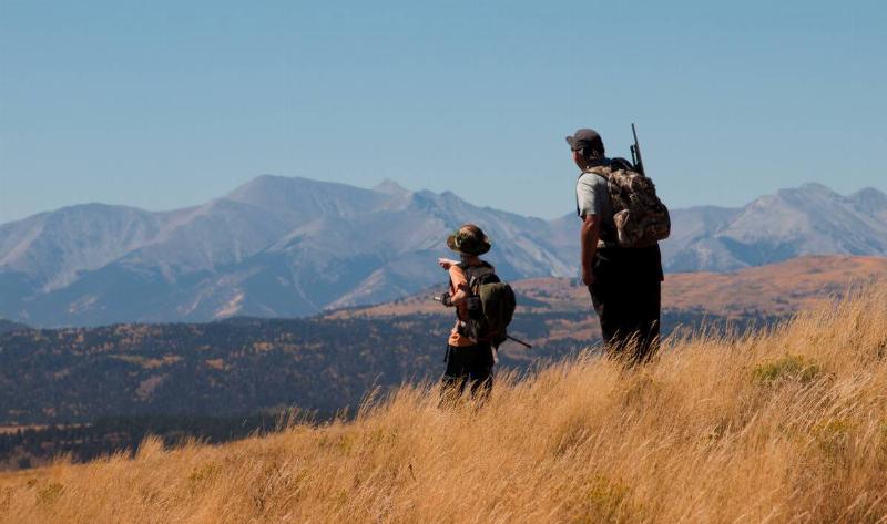 Two hunters hiking through some mountinas.