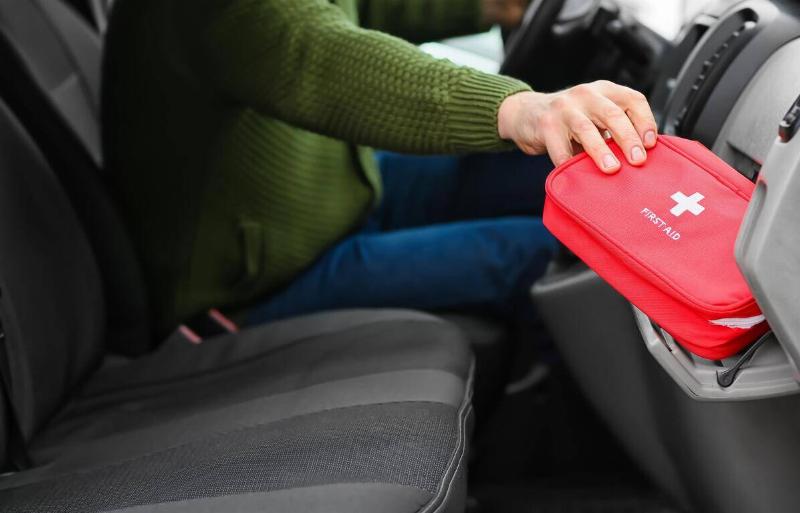 First aid kit being taken out of a car glovebox by the driver.
