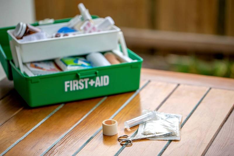 First aid kit on the table in the garden, green box