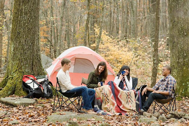 Friends camping together in fall. 