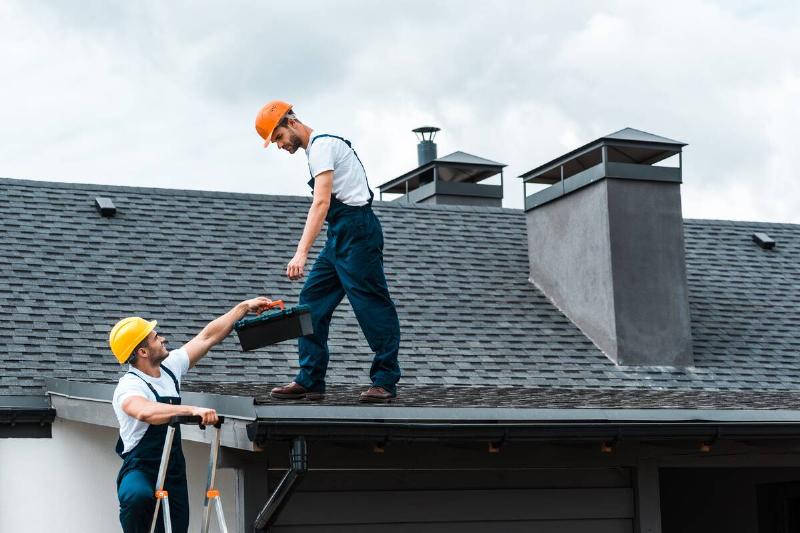 Two workers on a roof doing an inspection.