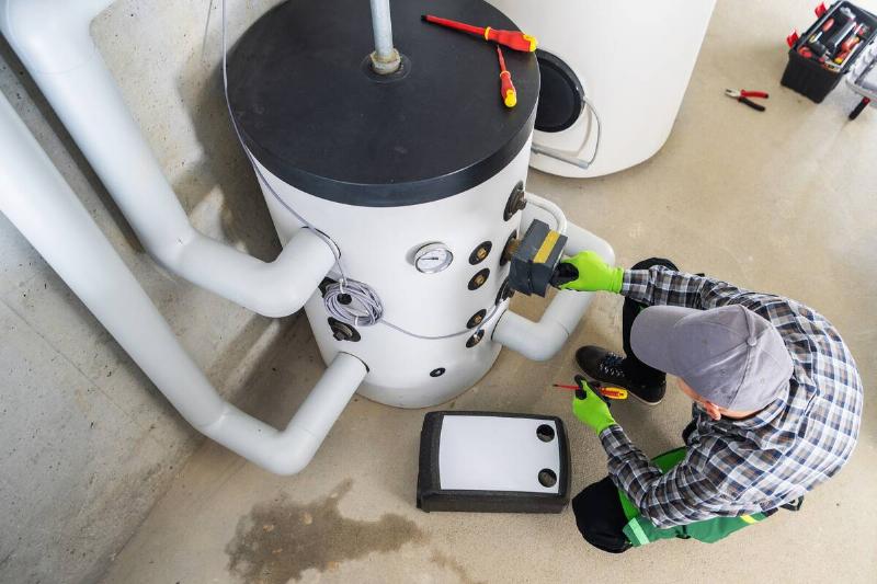 Water heater technician doing maintenance.