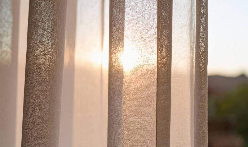 The sun shining through a sheer curtain.