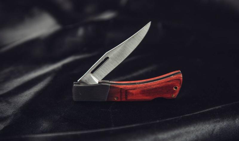 A half-open switchblade on black fabric.