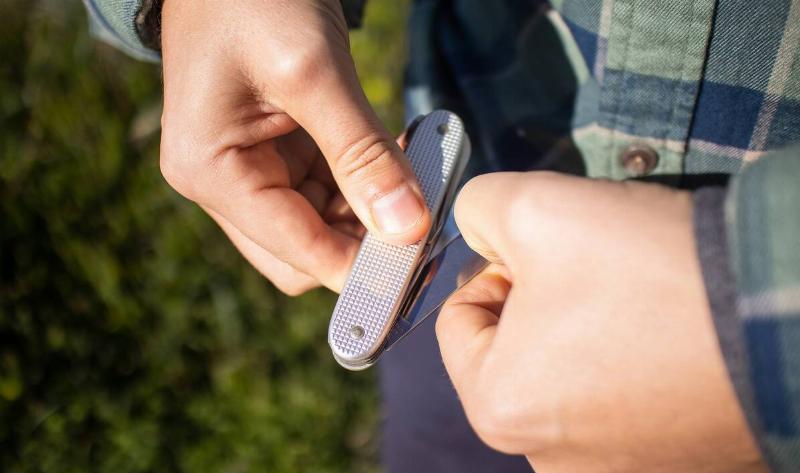 A person opening a multitool.